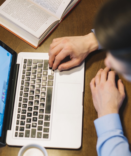 from man using laptop near book from man using laptop near book